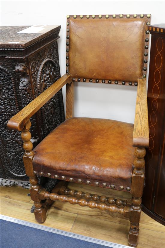 A pair of oak leather elbow chairs